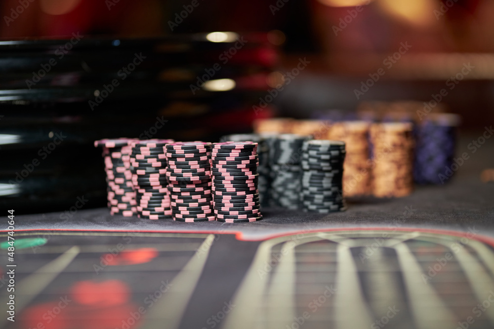 Multicolored casino table with roulette in motion, with multicolored casino chips. multi-colored poker chips. casino chips. online casino, poker, gambling. Gaming table Multicolored casino table with roulette in motion, with multicolored casino chips. multi-colored poker chips. casino chips. online casino, poker, gambling. Gaming table