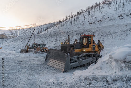Bulldozer on a parking lot in winter time. Gold mining site.