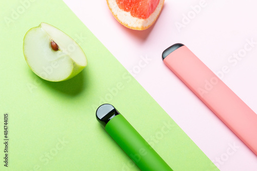 Electronic cigarettes with different fruit flavors with ingredients on colored backgrounds