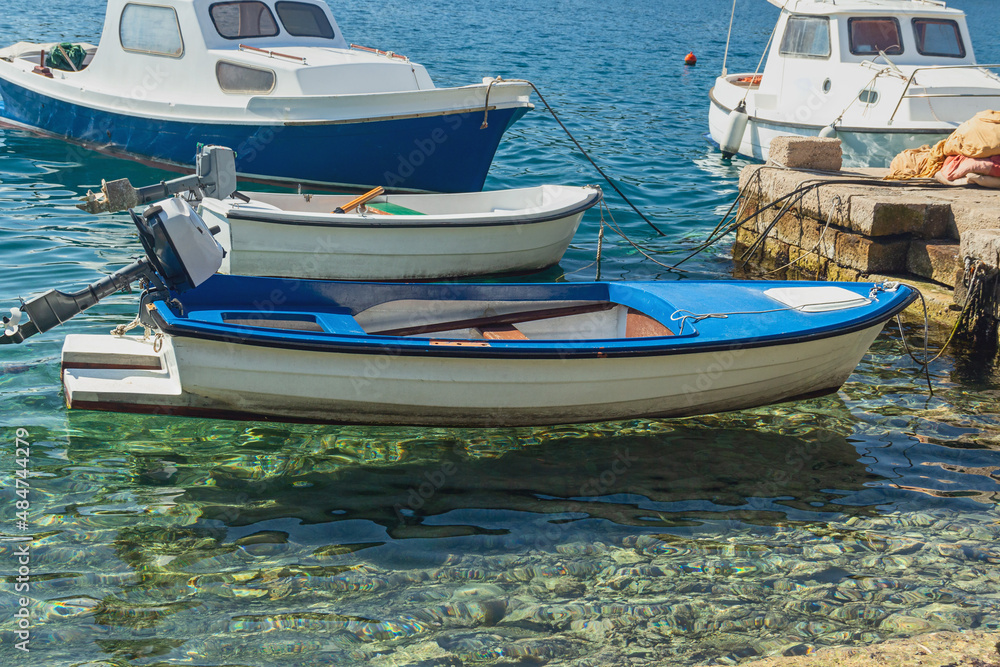 small rowing and motor boats parked in transparent sea water off the coast of Croatia small rowing and motor boats parked in transparent sea water off the coast of Croatia