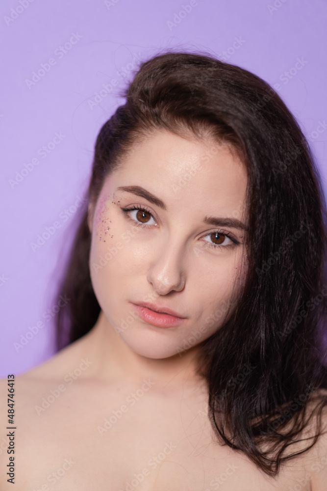 portrait brunette woman girl female on Very Peri background. with sequins on face. trendy color 2022. light purple. violet. portrait brunette woman girl female on Very Peri background. with sequins on face. trendy color 2022. light purple. violet.