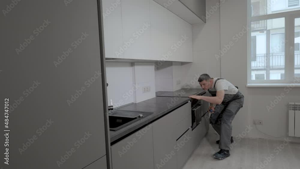 The builder checks the dimensions and quality of installation of the kitchen furniture structure The builder checks the dimensions and quality of installation of the kitchen furniture structure