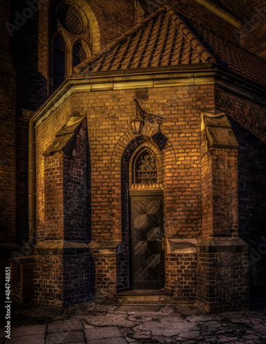 stary gotycki kościół z cegły pięknie oświetlony nocą
