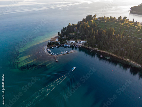 Aerial drone  wide photo of famous small port and fishing village of Kouloura with turquoise and emerald clear waters, Corfu island, Ionian, Greece photo