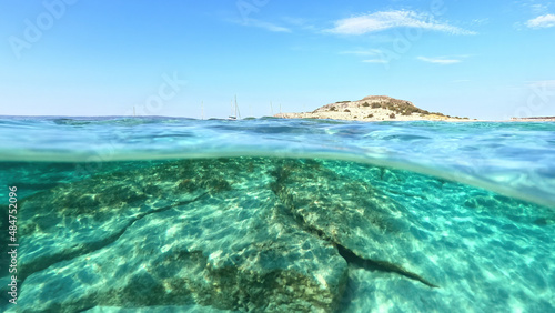 Underwater split photo of paradise exotic island beach with crystal clear turquoise sea in exotic destination island