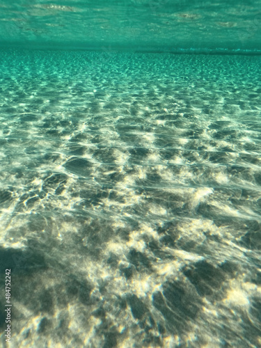 Underwater split photo of paradise exotic island beach with crystal clear turquoise sea in exotic destination island