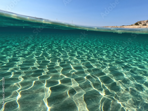 Underwater split photo of paradise exotic island beach with crystal clear turquoise sea in exotic destination island