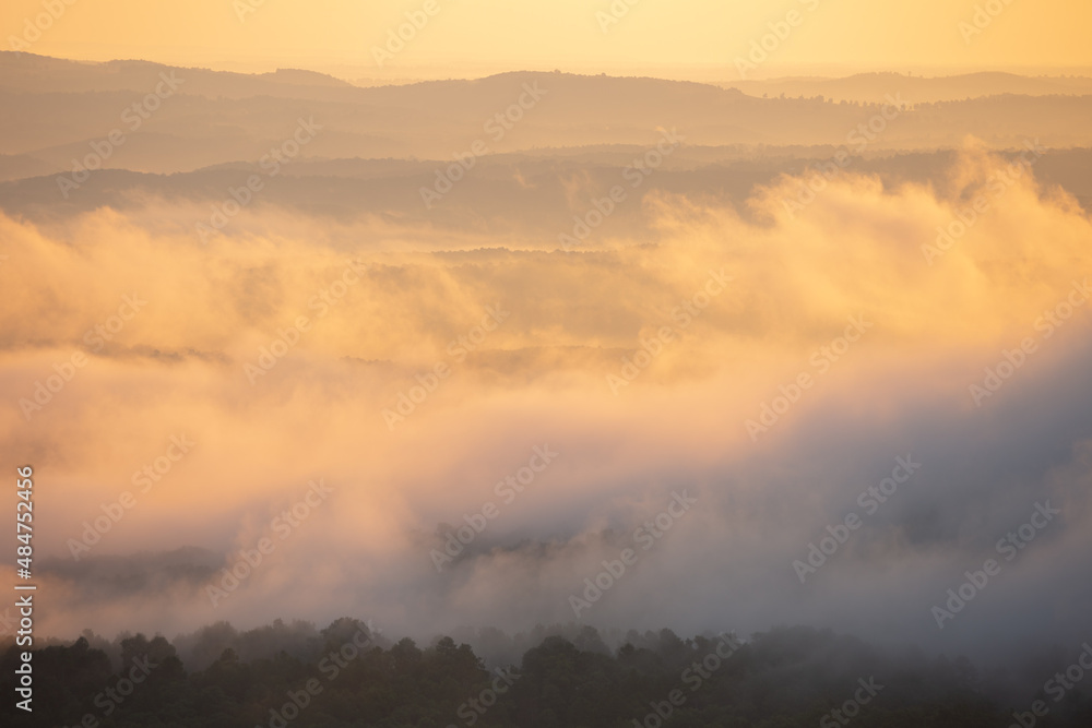 Fototapeta premium Foggy cloudy mist with sunrise glow over Grand Canyon mountains in Arkansas