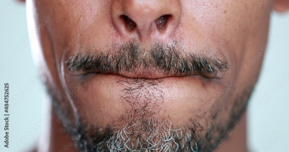 Obraz premium Man with mouth zipped, lips pressed close-up, feeling anxiety