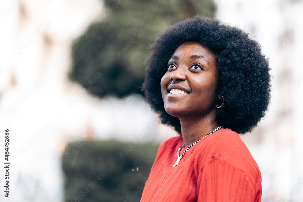 Happy and dreamy african woman looking at the sky Happy and dreamy african woman looking at the sky