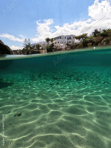 Underwater split photo of small bay and pituresque village of Avlemonas with emerald crystal clear sea in island of Kythira, Ionian, Greece