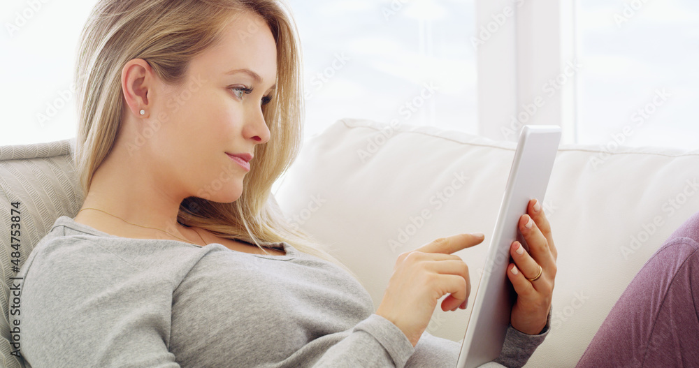 Connectivity at your fingertips. Shot of a pregnant woman using a tablet at home. Connectivity at your fingertips. Shot of a pregnant woman using a tablet at home.