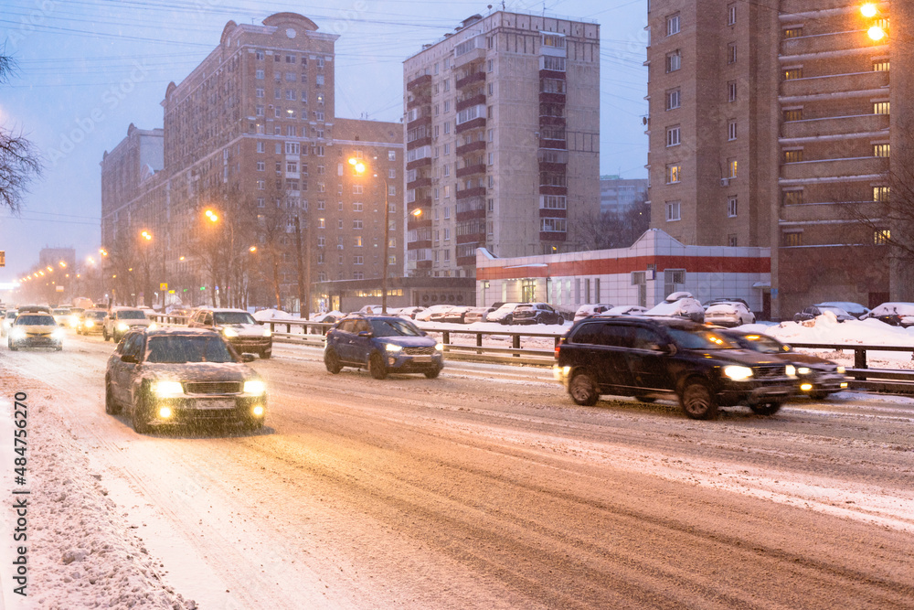 traffic on slippery snowy city road in snowfall