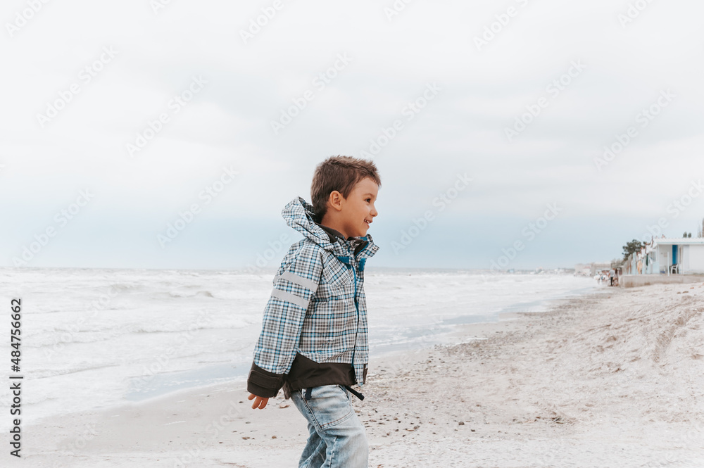 portrait of a attractive handsome smiling boy in a vest. Funny cute child in summer by stormy sea weather. Happy childhood. portrait of a attractive handsome smiling boy in a vest. Funny cute child in summer by stormy sea weather. Happy childhood.