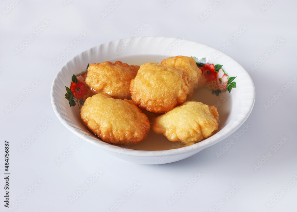 GUATEMALAN BUÑUELOS MADE OF FRIED DOUGH AND PLACED IN A PLATE FILLED WITH A SPECIAL HONEY LIQUID GUATEMALAN BUÑUELOS MADE OF FRIED DOUGH AND PLACED IN A PLATE FILLED WITH A SPECIAL HONEY LIQUID