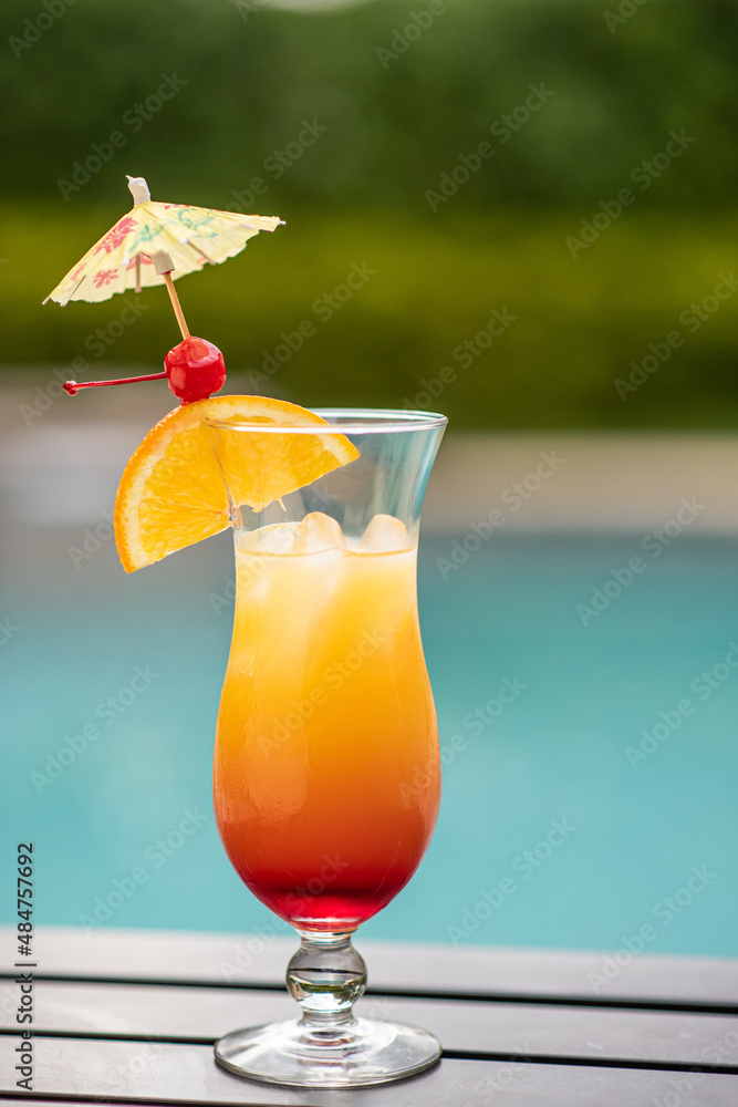 A red and yellow cocktail poolside