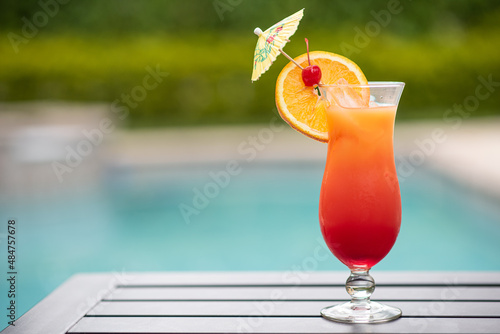 a cocktail glass by the pool on the right side