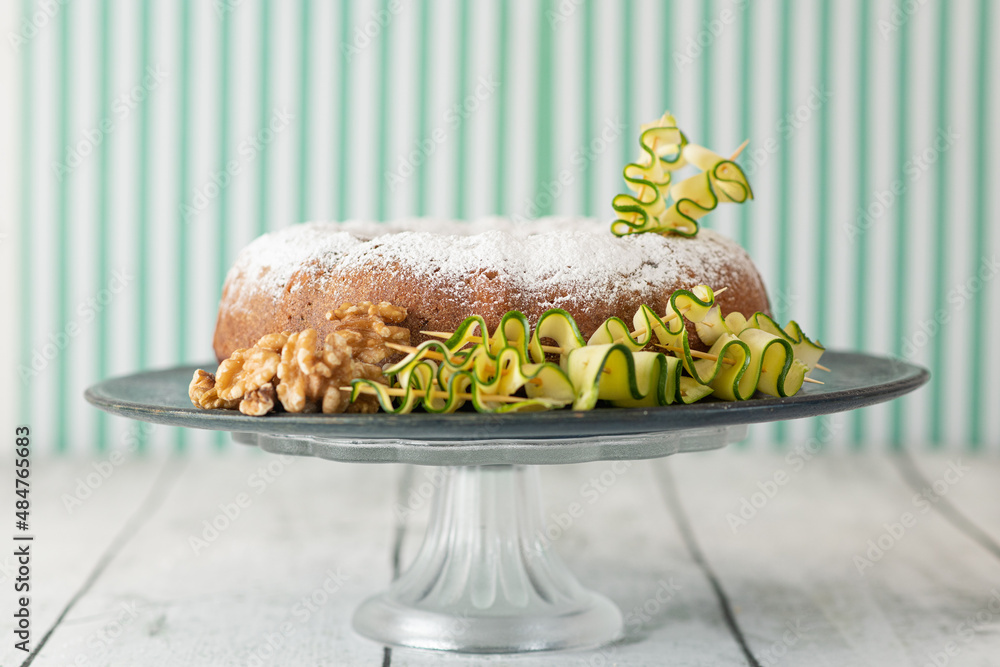 A zucchini and walnut cake decorated with ingredients