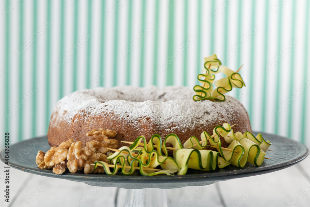 A zucchini and walnut cake decorated with ingredients