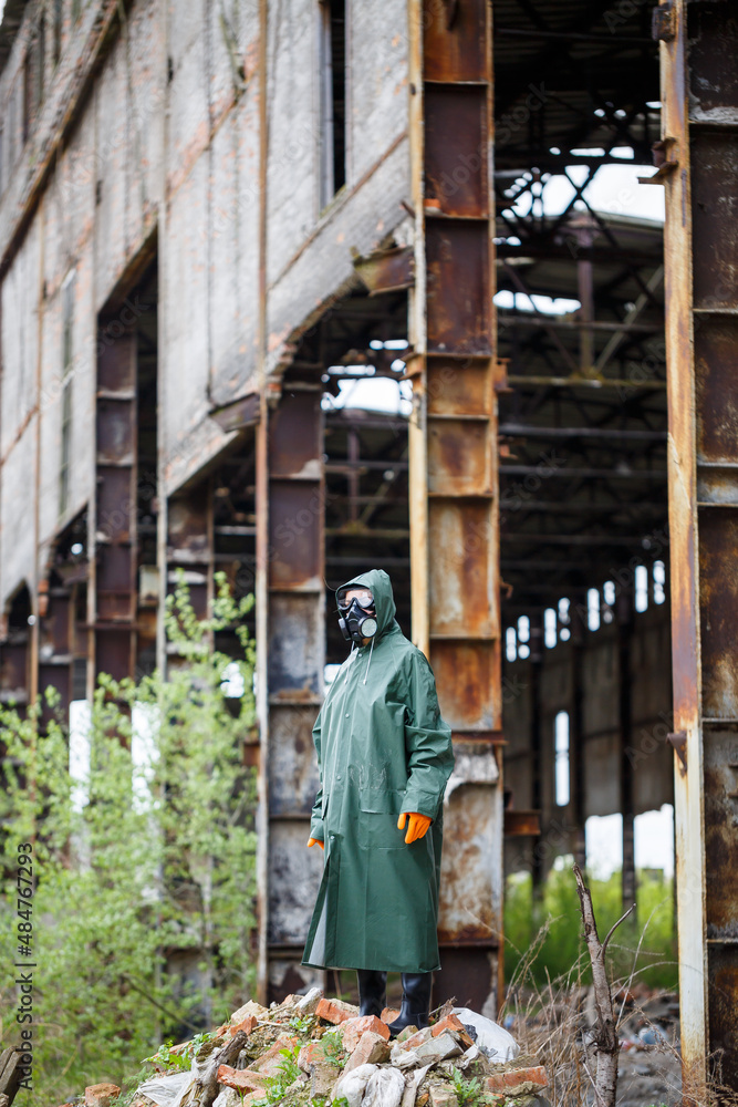 A man with a protective mask and protective clothing examines the danger zone. Ecological catastrophe. Dangerous toxic zone A man with a protective mask and protective clothing examines the danger zone. Ecological catastrophe. Dangerous toxic zone
