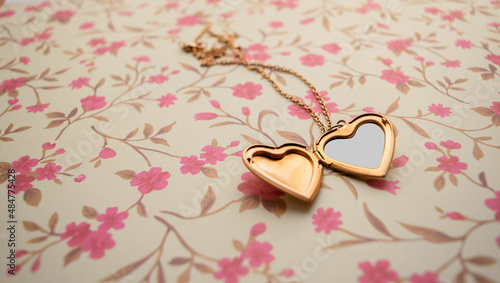Gold Heart Pendant over a Romantic Floral Vintage Background photo