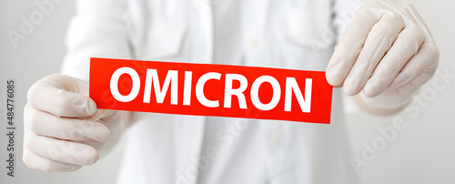 Omicron red warning sign with text new Omicron variant covid 19 in doctor hands in white coat and gloves. Long web banner
