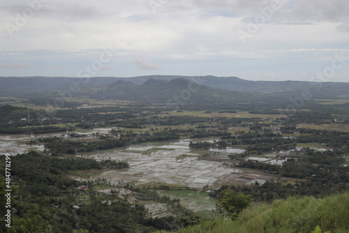 Hills and rice fields view on a cloudy day from Puncak Darma, Ciletuh UNESCO Global Geopark. Puncak Darma is one of the highest plateaus in the Ciletuh Geopark area, Sukabumi, West Java, Indonesia. photo