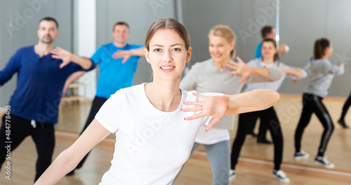 Cheerful young woman enjoying active dances in modern dance studio..