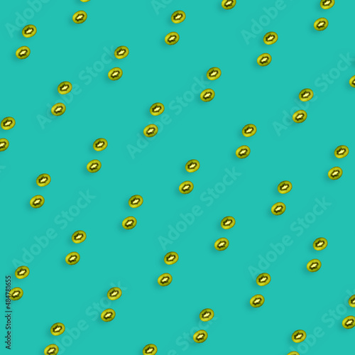 Colorful fruit pattern of fresh kiwi slices on turquoise background. Top view. Flat lay. Pop art design