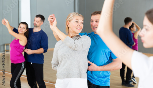 Positive mature woman learning to dance kizomba with partner in dancing class © JackF