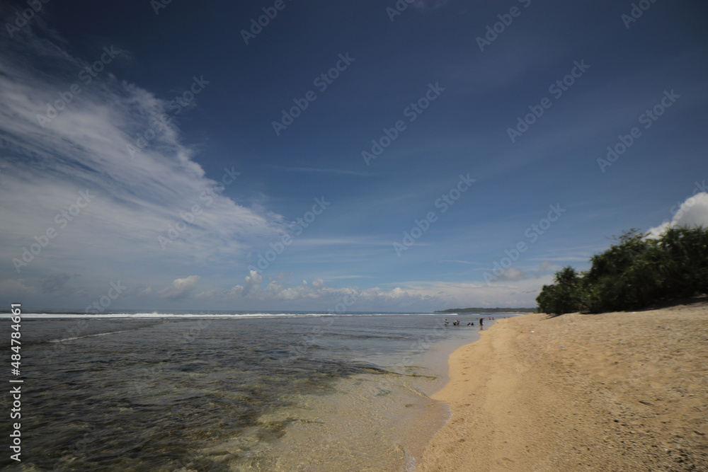 Beautiful tropical beach with blue sky and majestic clouds at Cibuaya Beach Ujung Genteng Sukabumi, West Java, Indonesia.