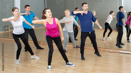 Group of adult people training in gym  doing aerobics exercises