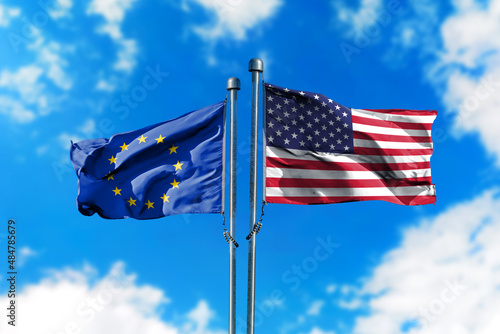 Flags of European Union and America on the wind against blue sky