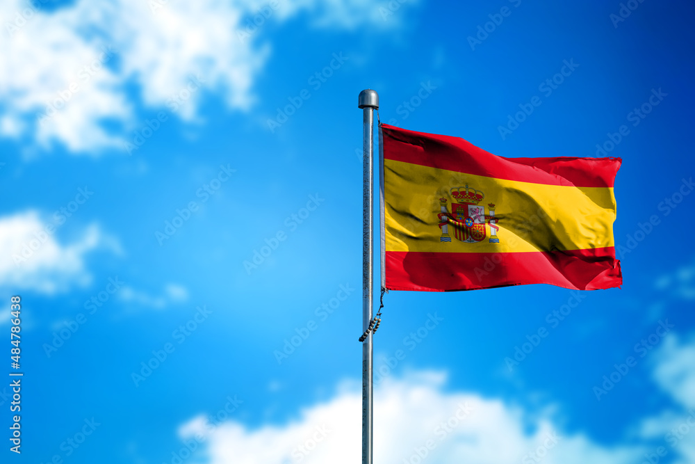 Flag of Spain on the wind against blue sky Flag of Spain on the wind against blue sky