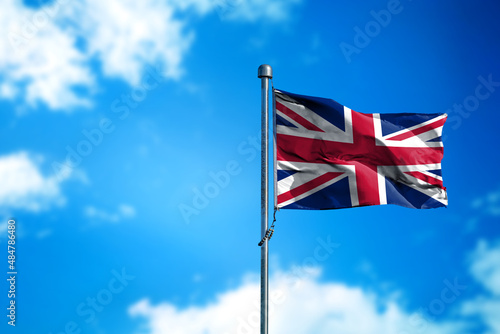 Flag of United Kingdom on the wind against blue sky