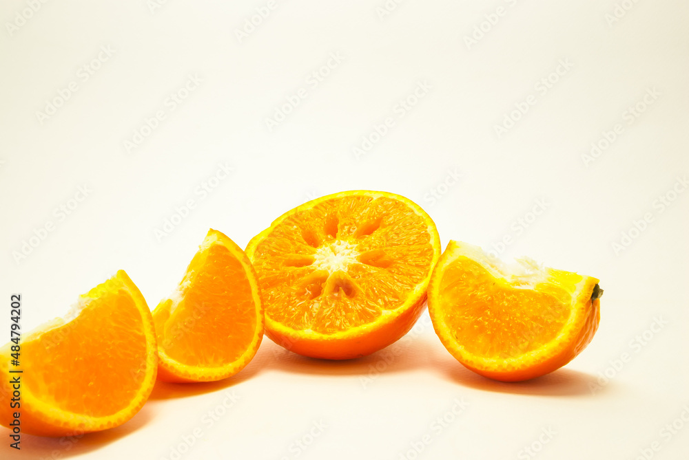 A sliced orange fruit. Fresh-looking yellow fruit on a white background. Fruits with vitamins and good health focus on specific points. Advertising concept and healthy food, space for text