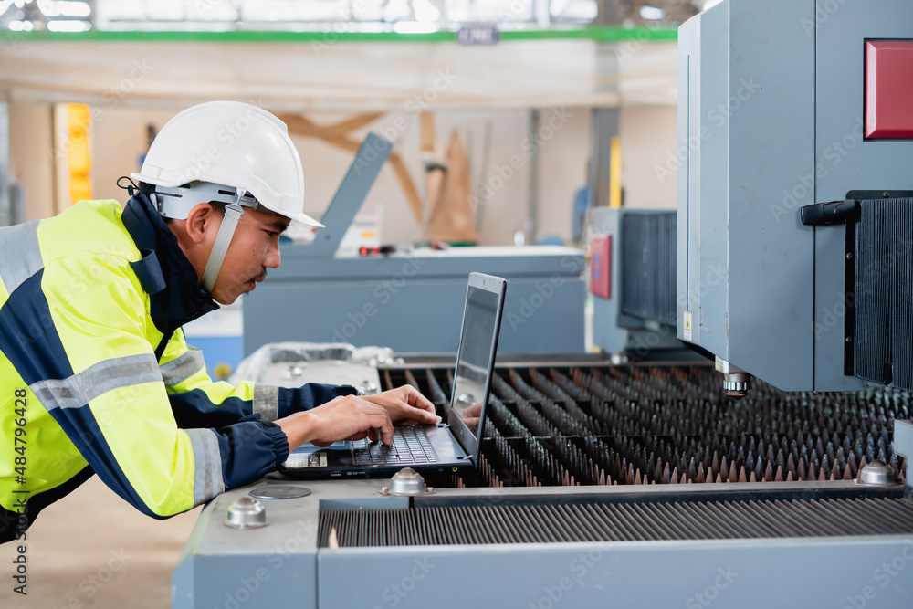 Asian male industrial engineer using laptop He made a gesture while working in a heavy industrial factory. Asian male industrial engineer using laptop He made a gesture while working in a heavy industrial factory.