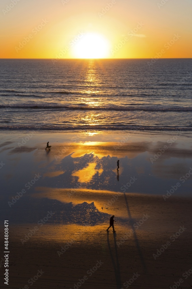 Vertical Landscape View of Sunset Sky over Pacific Ocean Horizon. People walking at Del Mar Beach San Diego, Scenic California Coastline