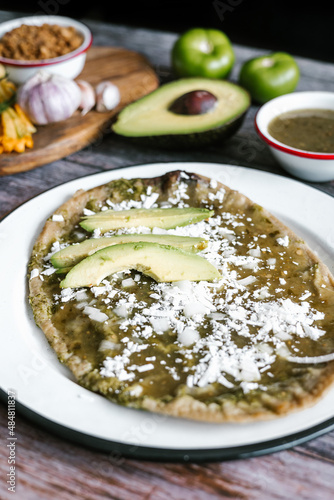 Memela sope quesadilla poblana of green sauce with cheese, onion and avocado traditional mexican food from Puebla, Mexico