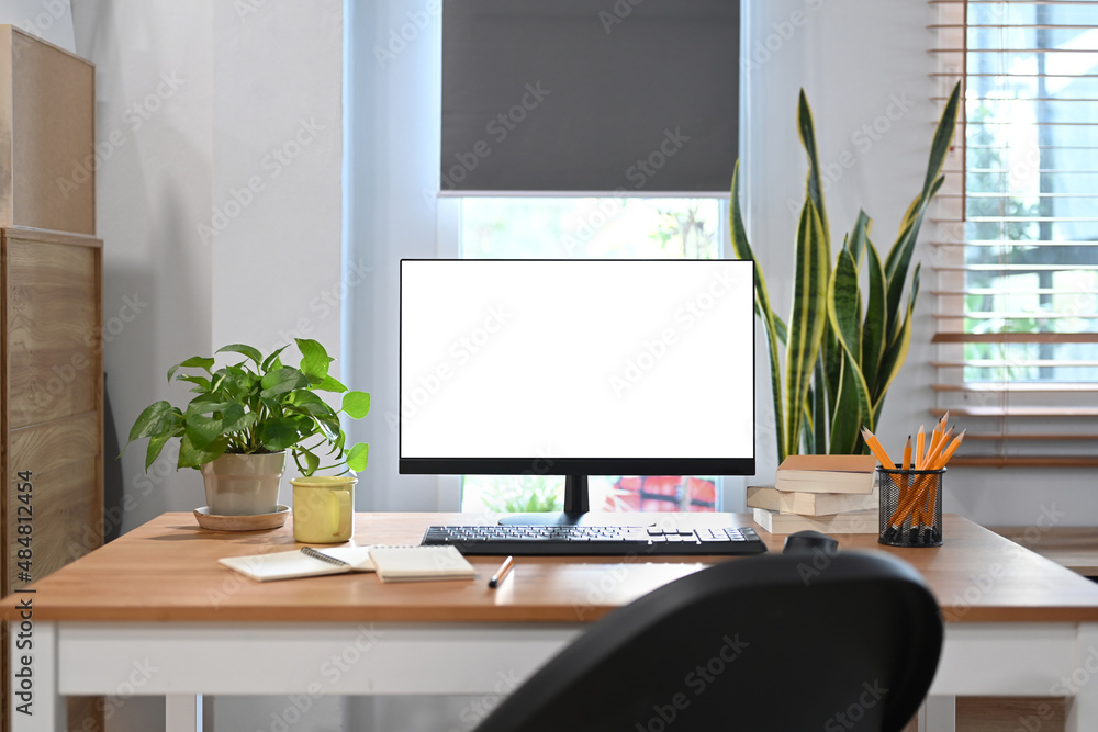 Fototapeta premium Comfortable workplace with computer pc, houseplant and supplies on wooden table.