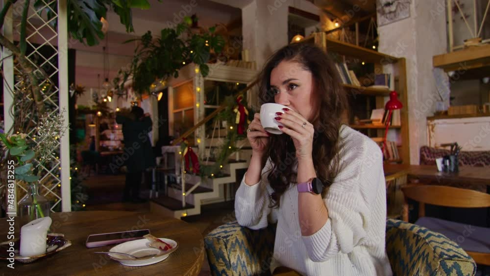 happy young woman drinking tea while sitting in a cafe. wonderful time in the cafe. happy young woman drinking tea while sitting in a cafe. wonderful time in the cafe.
