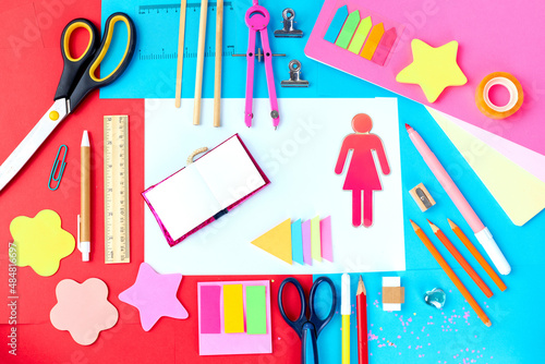 Flat lay top view of school supplies and stationery for girls, very bright and colorful, pink and blue accents - scissors, pencils, sharpeners, stickers, post-its