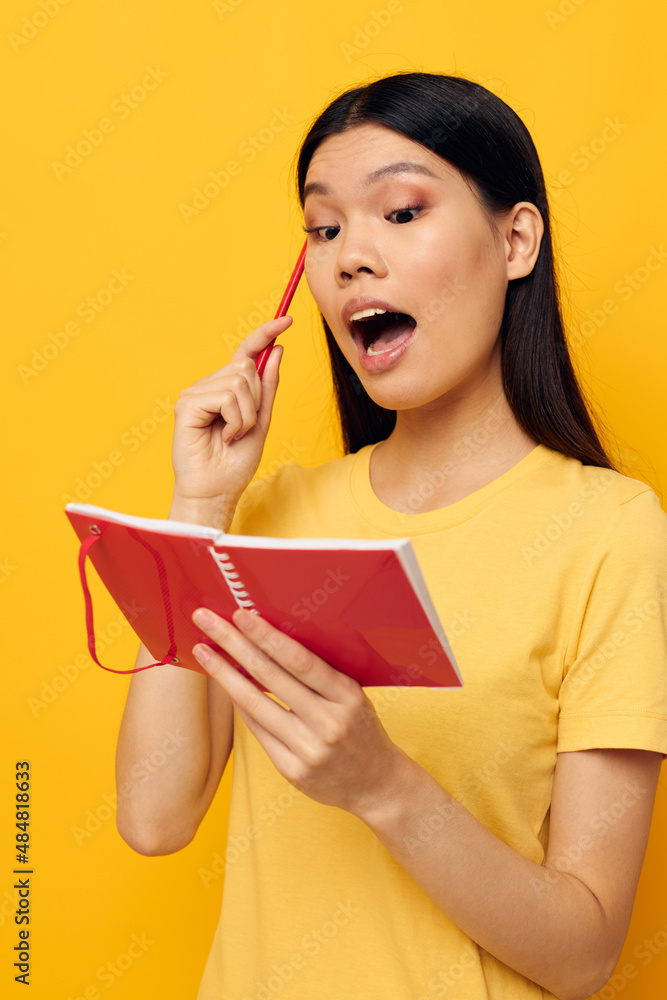 woman in a yellow t-shirt red notebook training yellow background unaltered woman in a yellow t-shirt red notebook training yellow background unaltered