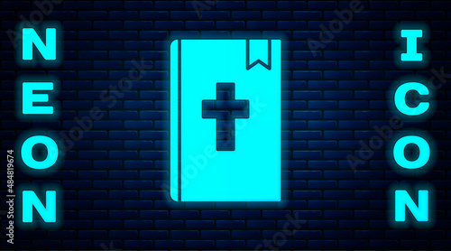 Glowing neon Holy bible book icon isolated on brick wall background. Vector