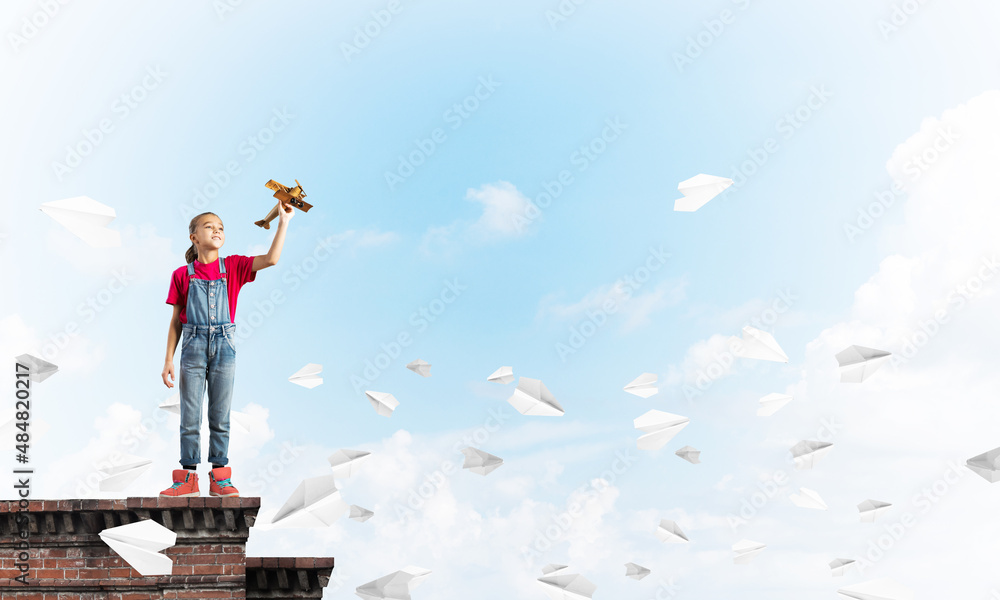 Concept of careless happy childhood with girl dreaming to become pilot Concept of careless happy childhood with girl dreaming to become pilot