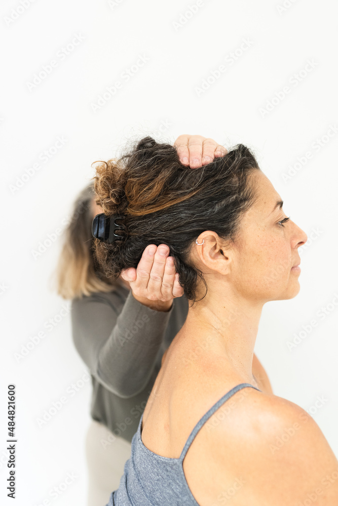 Naklejka premium Yoga and alternative therapies teacher, positioning a student in the head position.