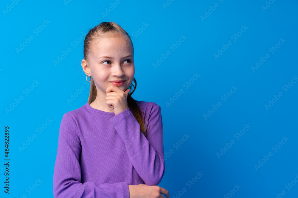 Little girl thinking and looking up over blue background Little girl thinking and looking up over blue background