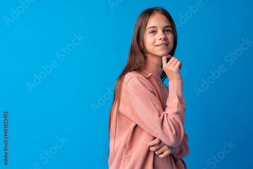 Portrait of pretty teen girl thinking and creating solution against blue background