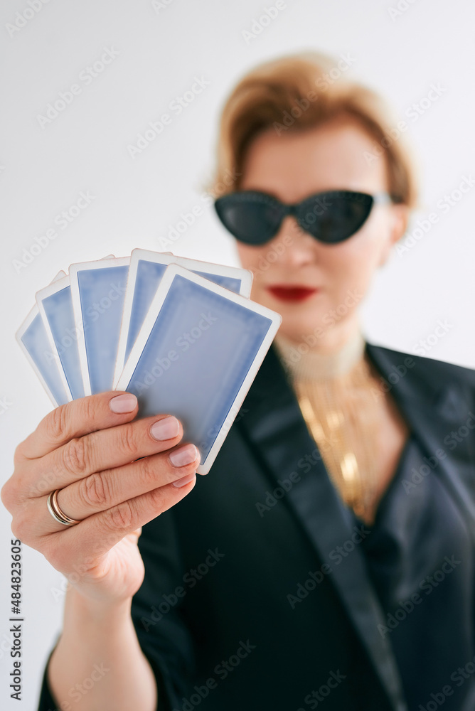 mature stylish woman in black tuxedo and sunglasses in casino. Gambling, fashion, poker face, royal flush, hobby concept. mature stylish woman in black tuxedo and sunglasses in casino. Gambling, fashion, poker face, royal flush, hobby concept.