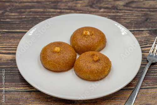 Traditional Turkish dessert sekerpare on a wooden background. Turkish dessert with syrup, ramadan and feast treat. Close up photo